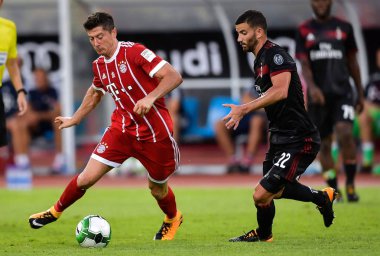 Robert Lewandowski, left, of Bayern Munich kicks the ball to make a pass against Mateo Musacchio of AC Milan during the Shenzhen match of the 2017 International Champions Cup China in Shenzhen city, south China's Guangdong province, 22 July 2017 clipart
