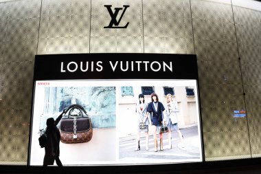 customer walks past a Louis Vuitton (LV) store in Nanning city, south China's Guangxi Zhuang Autonomous Region, 19 February 2017 clipart