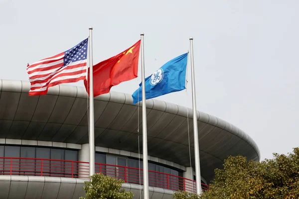 アメリカ合衆国 中国の国旗とゼネラル エレクトリック フラッター上海の Zhangjiang 上海の浦東のハイテクパークでの中国 3月2日2013 — ストック写真