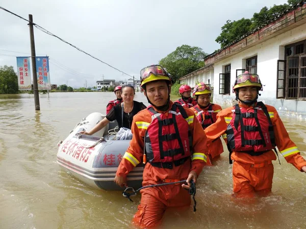 Yanshan 地区の豪雨による浸水地からのインフレータブル救命艇によって地元住民を避難させる中国人救助隊 南中国広西庄自治区 7月4日2017 — ストック写真