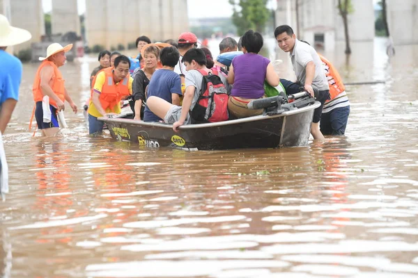 中国中央湖南省 長沙市の豪雨による浸水地域からの膨脹可能な救命艇により 中国人の救助者は地元住民を避難させる 7月2日2017 — ストック写真