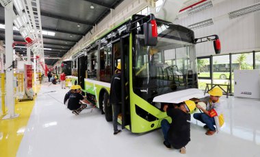 Chinese workers assemble new energy buses on the assembly line at an auto plant in Guigang city, south China's Guangxi Zhuang Autonomous Region, 5 July 2017 clipart