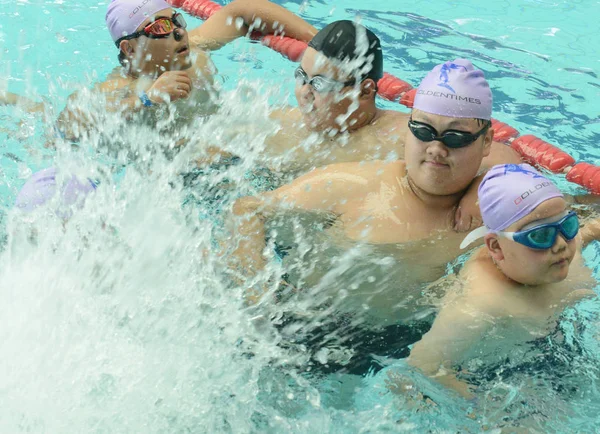 2017年7月12日 在中国中部河南省郑州市为超重儿童举办的夏令营中 肥胖的中国青年学生在游泳池里玩耍 — 图库照片