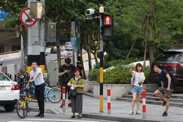 中国の市民は 中国上海の交差点でカメラの Jaywalkers をキャッチするために 試験電子警察の装置の前に赤の光が点灯するのを待ちます 月2017 — ストック写真