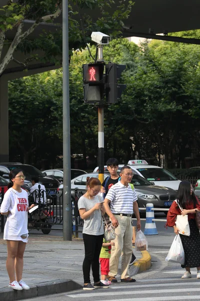 7月6日 在中国上海的一个十字路口 中国公民在一个试探性的电子警用设备前等待红灯变绿 在镜头前抓拍电子步行者 — 图库照片