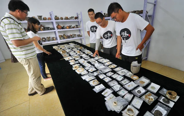 \Chinese workers display jadeware unearthed from the excavation site of the Jiaojia ruins, where skeletons reaching 1.9 meters were discovered from graves dating back to 5,000 years ago, in Jiaojia village, Zhangqiu district of Ji'nan city, ea — Stock Image Chinese Workers Display Jadeware Unearthed Excavation Site Jiaojia Ruins Skeletons Royalty Free Stock Photos