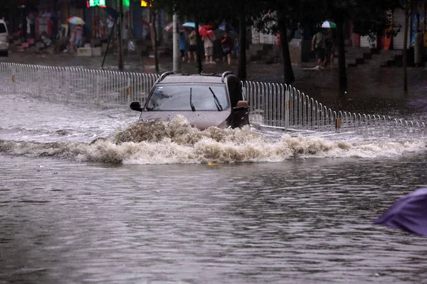 Ένα Αυτοκίνητο Ταξιδεύει Μέσα Από Ένα Πλημμυρισμένο Δρόμο Που Προκλήθηκε — Φωτογραφία Αρχείου