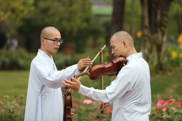 中国首家在湖北天台寺的古典佛教音乐专业学院的和尚和尼姑在黄龙音乐节和黄龙洞穴哈利路亚音乐厅的国际合唱周期间拉小提琴 — 图库照片