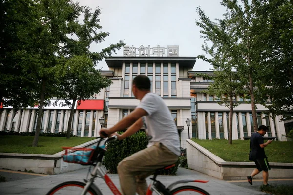 2017年8月17日 一名骑自行车的人在中国北京的 Sunac 中国控股有限公司办公楼前骑行 — 图库照片