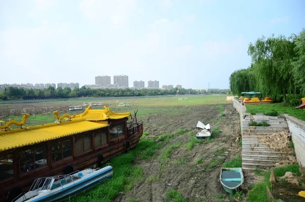 中国東部山東省松光市の干ばつ時に草に覆われた河川敷に投棄されたボートの眺め 2017年7月24日 — ストック写真