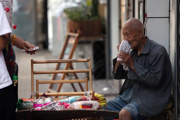 107歳の中国人男性 王Zhengrongは 中国の北京にある中国通信大学の西門でインソールを売っていると見られ 2017年8月17日 — ストック写真