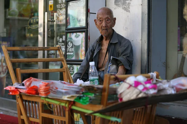 107歳の中国人男性 王Zhengrongは 中国の北京にある中国通信大学の西門でインソールを売っていると見られ 2017年8月17日 — ストック写真