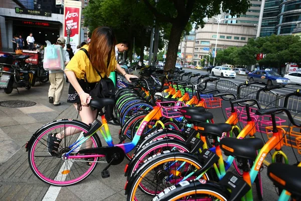 地元住民は 2017 上海の路上中国自転車共有サービス 7Sebike の七色の共有自転車を使用します — ストック写真