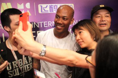 American basketball player Stephon Xavier Marbury, center, takes selfies with a fa clipart