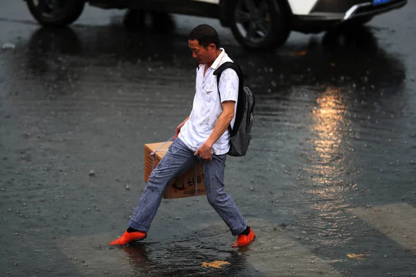 2017年8月23日 在中国西南部的云南省昆明市 一名中国通勤者在大雨和强风中走在斑马线上 — 图库照片