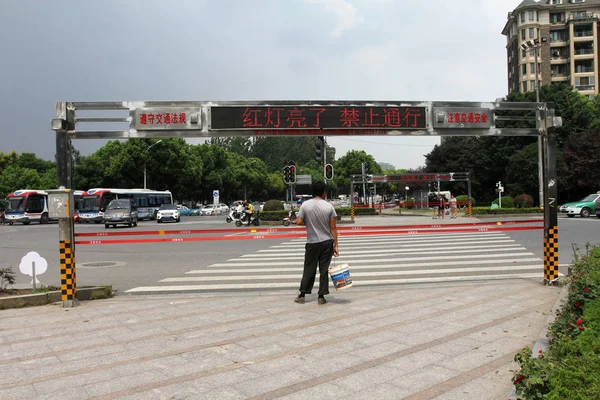 中国の湖北省 武漢市の通りの交差点で閉じた自動ロープシステムの前で赤信号が緑色に変わるのを待つ歩行者 月2017 — ストック写真
