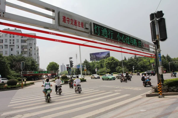2017年8月25日 中国中部の湖北省武漢市の交差点で自動ロープシステムが開通すると サイクリストは道路を横断します — ストック写真