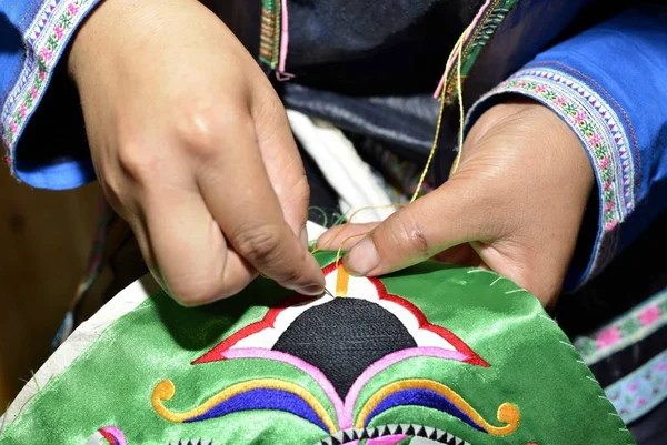 伝統的な衣装を着たミアオ族の中国人女性が 中国南西部の貴州省 青雲南省のミオドン郡で カラフルな絹と鳥の羽を刺繍した100羽の衣装を作る — ストック写真