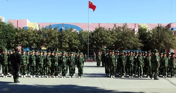 初等部の学生は 中国の新疆ウイグル自治区であるアルタイ山脈県の学期の初めに 学校での軍事訓練に参加します 月2017 — ストック写真