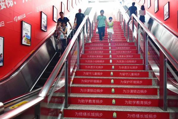 乗客が 2017 日中国東部の浙江省杭州市の地下鉄ライン Fengqi の道の駅でお金を寄付する乗客の手順を記録する赤外線検出器搭載の階段を歩く — ストック写真