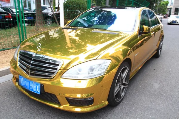 Ένα Χρυσό Αυτοκίνητο Mercedes Benz Είναι Σταθμευμένο Μπροστά Από Ένα — Φωτογραφία Αρχείου