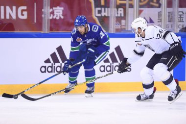 Brandon Sutter, left, of Vancouver Canucks competes against Derek Forbort of Los Angeles Kings during the second NHL China preseason hockey game at Wukesong Arena in Beijing, China, 23 September 2017 clipart