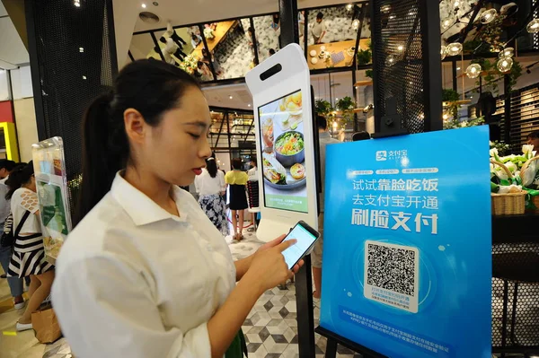 顧客は 2017年8月31日 中国東部の浙江省杭州市にあるKfc初のKproレストランで 食品と顔認識の支払いを注文する機能を持つ注文機を見ます — ストック写真