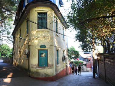 Tourists walk past colonial buildings in an alley on the Gulangyu Island in Xiamen city, southeast China's Fujian province, 24 November 2015 clipart