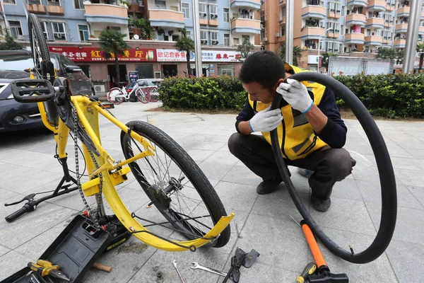 46岁的中国维修运营商刘洪兵于2017年9月1日在中国中部湖北省向阳市的一条街道上维修自行车轮胎 — 图库照片