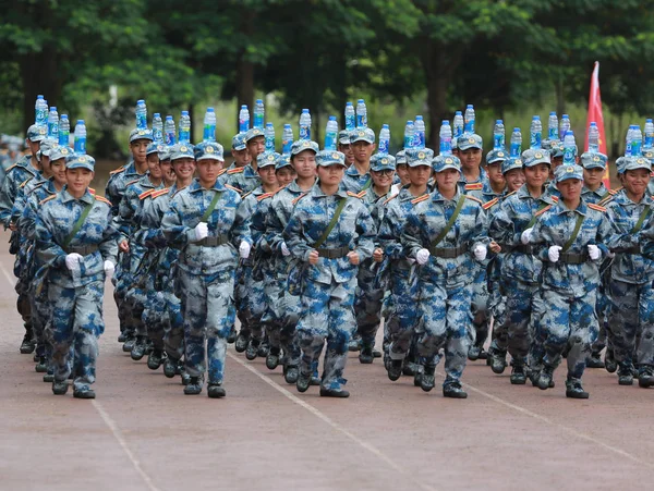 新入生として彼らは軍事訓練で屋外陸上競技場南寧市の大学のキャンパスに中国南部の広西チワン族自治区南寧市職業技術の 2017 頭にボトルのバランスをとる — ストック写真