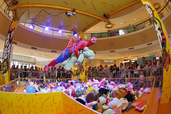 An employee dressed as Spider-Man who is buckled in to act as a human claw machine shows to grab toys at a shopping mall in Yantai city, east China\'s Shandong province, 16 September 2017