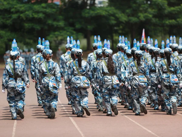 新入生として彼らは軍事訓練で屋外陸上競技場南寧市の大学のキャンパスに中国南部の広西チワン族自治区南寧市職業技術の 2017 頭にボトルのバランスをとる — ストック写真