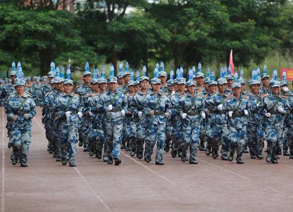 新入生として彼らは軍事訓練で屋外陸上競技場南寧市の大学のキャンパスに中国南部の広西チワン族自治区南寧市職業技術の 2017 頭にボトルのバランスをとる — ストック写真