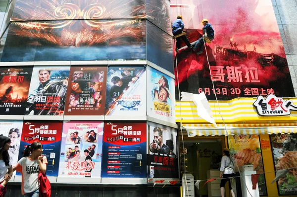 2014年6月11日 中国工人在中国上海的一家电影院安装巨型电影海报 — 图库照片