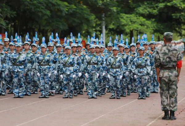 新入生として彼らは軍事訓練で屋外陸上競技場南寧市の大学のキャンパスに中国南部の広西チワン族自治区南寧市職業技術の 2017 頭にボトルのバランスをとる — ストック写真