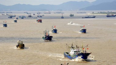 Chinese fishing boats set out to fish from a port in Zhoushan city, east China's Zhejiang province, 17 September 2017 clipart