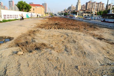 View of flat ground after the nail house in the middle of North Huting Road, whose owner refused to move out due to disputes over compensation details for 14 years, was demolished in Songjiang district, Shanghai, 18 September 2017 clipart