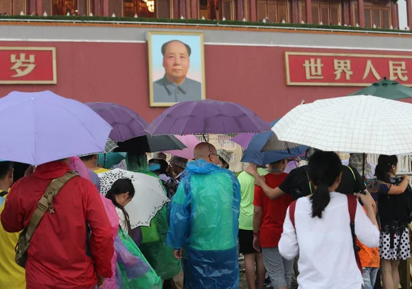 2017年8月12日 中国北京天安门广场上 身穿雨衣 持雨伞的游客在大雨中合影 — 图库照片