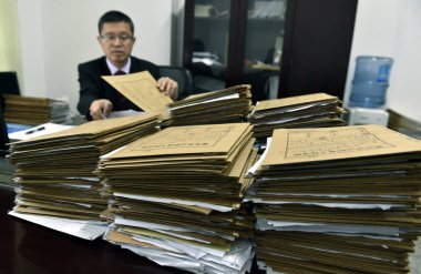--FILE--An executive judge checks the documents of a case at the Yunyang People's Court in Yunyang county, Chongqing, China, 25 April 2017 clipart
