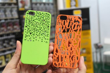 A visitor shows a 3D printed phone cases for Apple's iPhone smartphones during the 2013 Macworld iWorld Asia (MIA) in Beijing, China, 25 August 2013 clipart