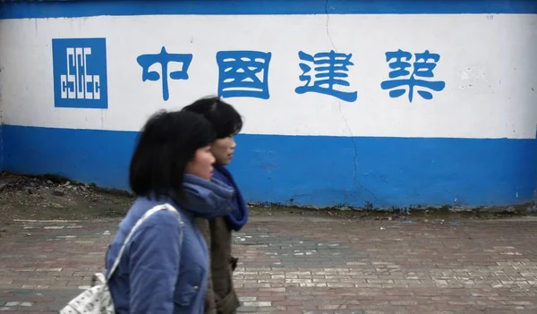 行人走过中国国家建筑工程总公司 中国建筑工程总公司 在中国中部湖北省武汉市的一个施工现场 2013年3月1日 — 图库照片