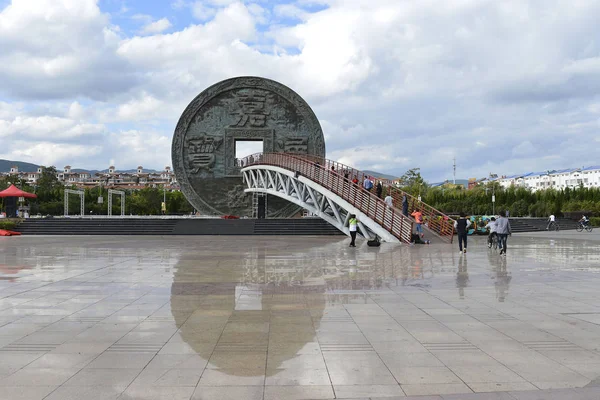 2017年10月1日 在中国西南云南省曲靖市惠泽县的一个公园里 当地居民和游客走过一座以巨大青铜硬币形状为特色的雕塑 — 图库照片