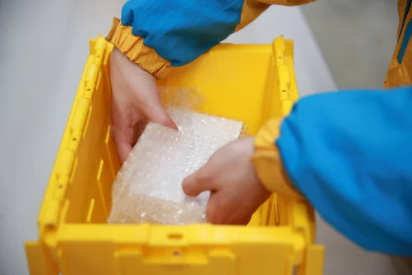 Een Werknemer Verpakt Met Een Herbruikbare Doos Voor Expreszendingen Een — Stockfoto