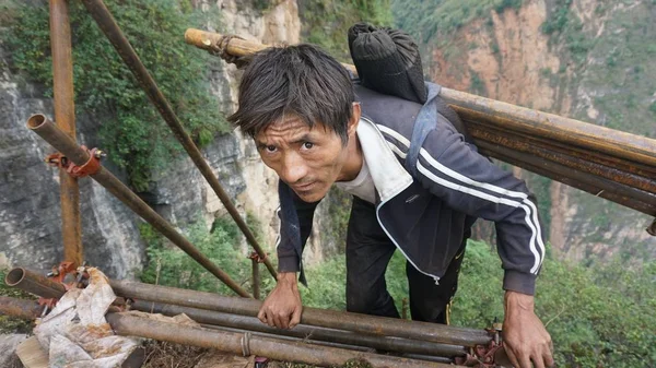 Ein Chinesischer Dorfbewohner Klettert Mit Stahlrohren Auf Einer Stahlleiter Auf — Stockfoto