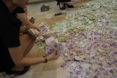 Female Chinese employees collect and count one-yuan and 50-cent banknotes paid by an elderly couple as earnest money to buy an apartment at the sales center of a residential property project in Anyang city, central China's Henan province, 12 Septembe clipart