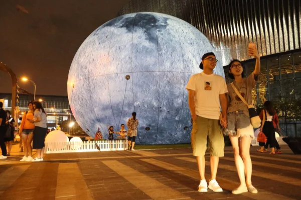 Casal Posa Para Selfies Frente Uma Esfera Gigante Simulando Lua — Fotografia de Stock