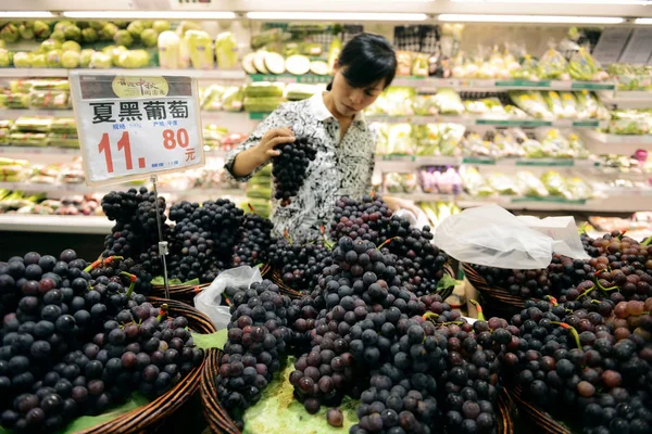 中国人買い物客が中国東部山東省青島市のスーパーマーケットでブドウを買う 2016年9月9日 — ストック写真