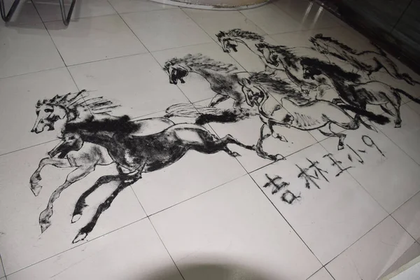 中国の美容師 Wang Xiaojiu によって作られた8つの疾走する馬が 吉林2016省にある彼の理髪店で床に髪をつけた絵の図 — ストック写真