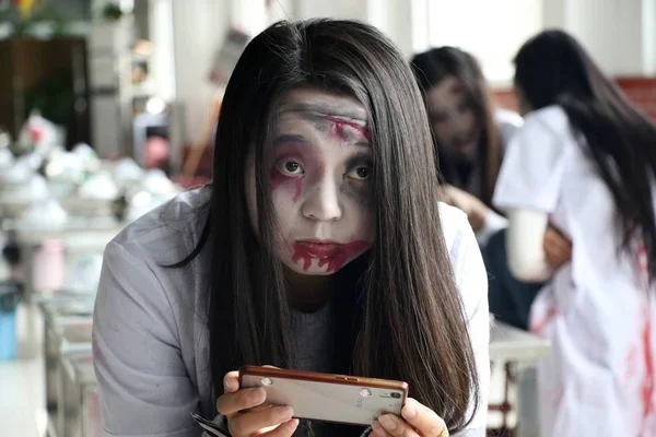 Молодая Женщина Зомби Макияжем Использует Свой Смартфон Время Собрания Отпраздновать — стоковое фото