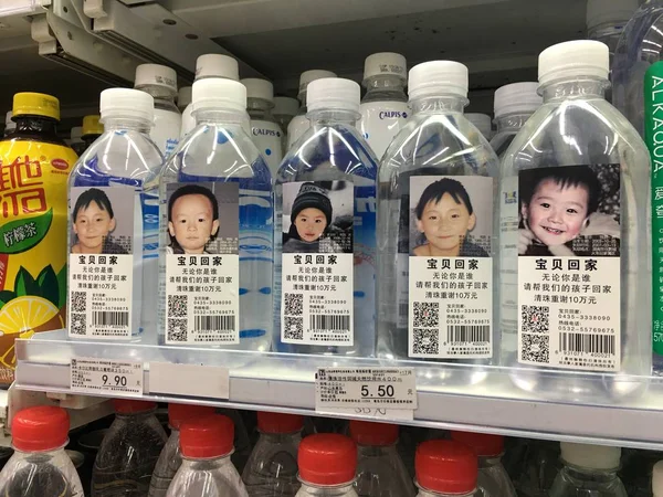 写真付きの Drining 水と行方不明の子供たちの個人情報をラベルとしたボトルは Ciy 東シナの山東省 11月14日2016のコンビニエンスストアで販売されています — ストック写真